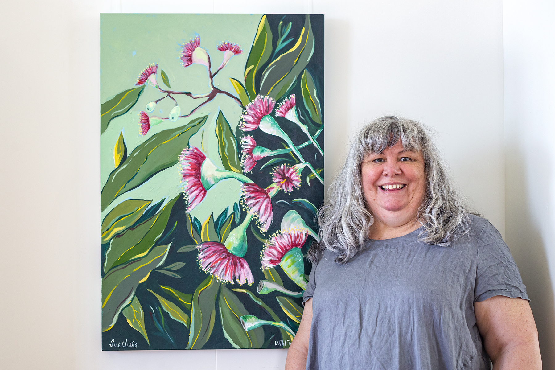 Person standing next to their artwork